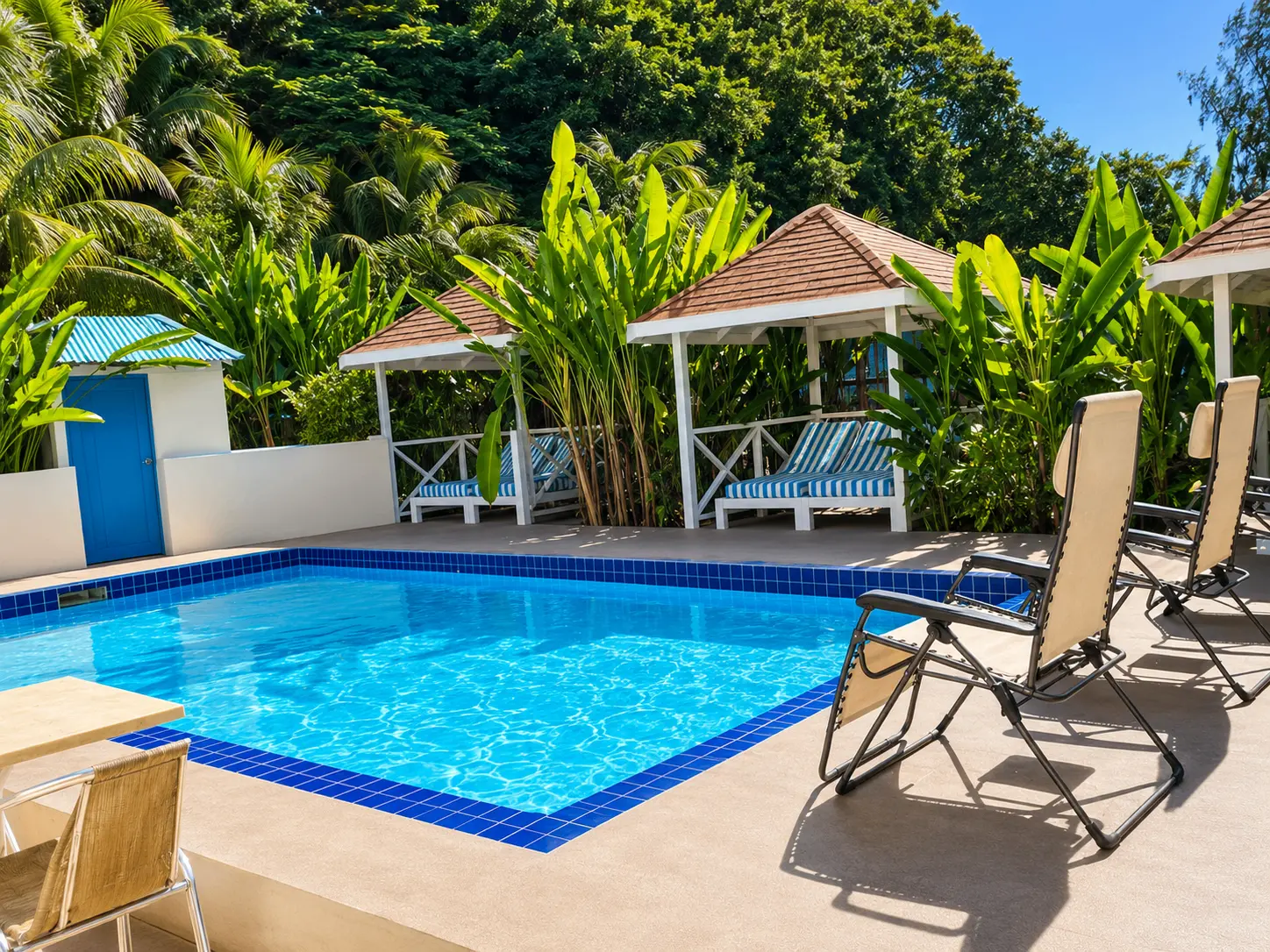 Loungers and cabanas beside the pool on the waterfront terrace at Point Bay Resort